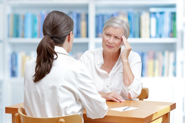 &Auml;rztin mit einer &auml;lteren Patientin, die an Long COVID leidet